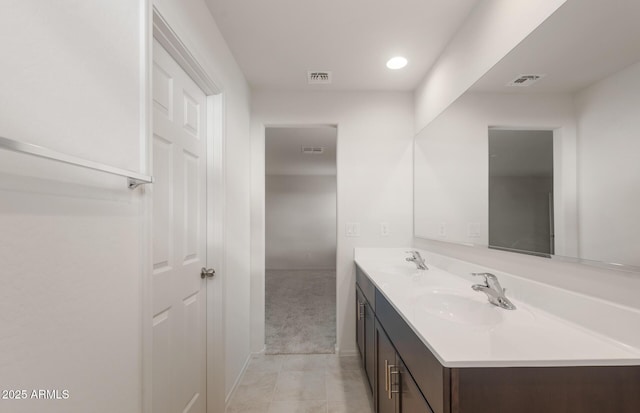 bathroom featuring visible vents, a sink, and double vanity
