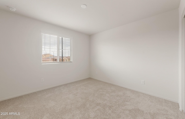 carpeted empty room with baseboards