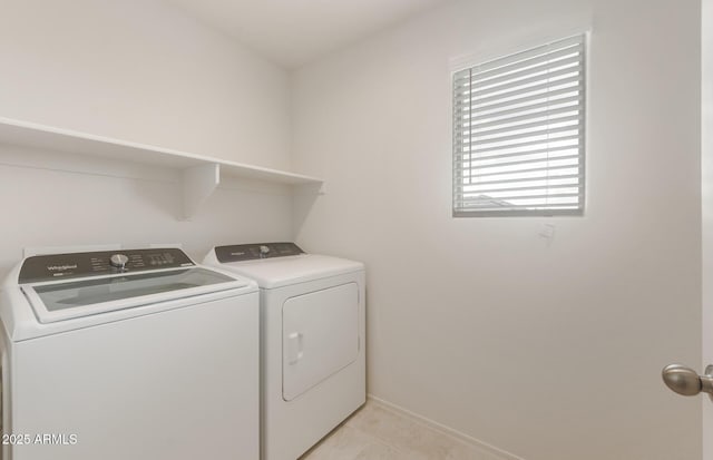 washroom with light tile patterned floors, baseboards, separate washer and dryer, and laundry area