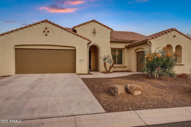 mediterranean / spanish-style house with a garage