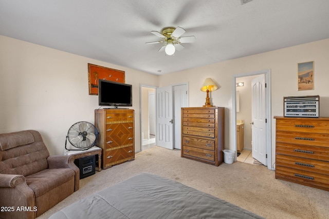 carpeted bedroom featuring a ceiling fan and ensuite bath