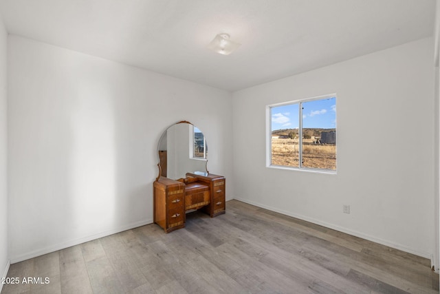 interior space with baseboards and wood finished floors