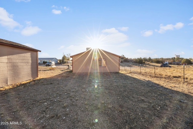 view of yard featuring fence and an outbuilding