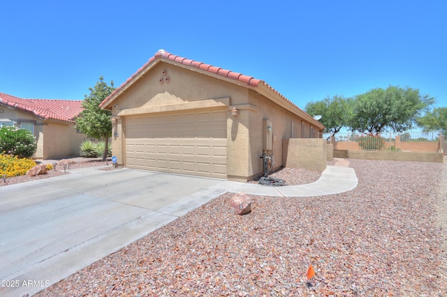 103 S Birdie Way, Casa Grande, AZ 85194 - view of front of house featuring stucco siding, concrete driveway, a tile roof, and an attached garage