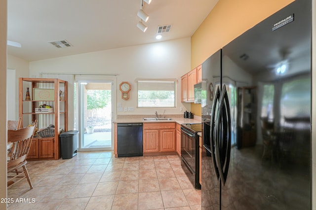 103 S Birdie Way, Casa Grande, AZ 85194 - kitchen with black appliances, vaulted ceiling, light countertops, light brown cabinetry, and light tile patterned floors