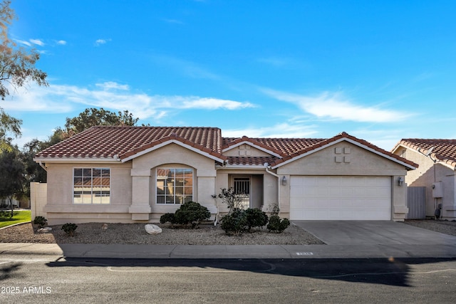 mediterranean / spanish house featuring an attached garage, a tiled roof, concrete driveway, and stucco siding