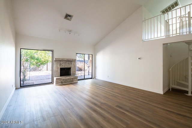 unfurnished living room featuring high vaulted ceiling, hardwood / wood-style flooring, and track lighting