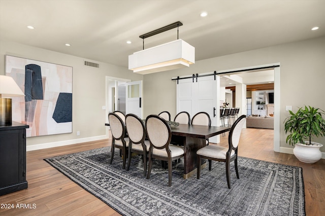 dining room featuring wood-type flooring and a barn door