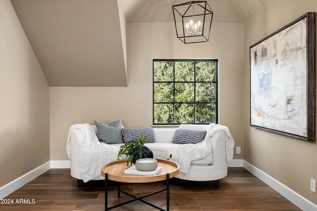 sitting room with dark wood-type flooring, a chandelier, and lofted ceiling