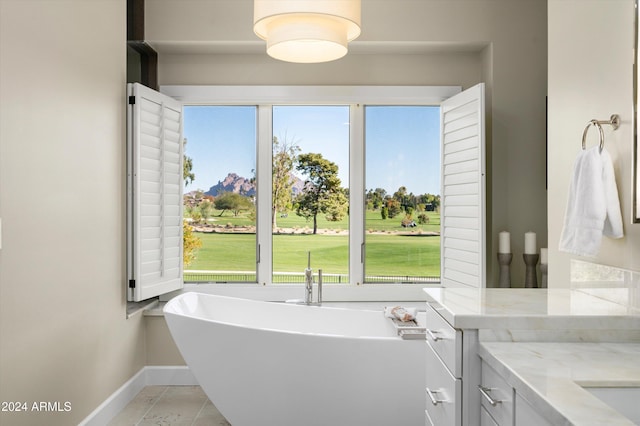 bathroom with a tub and vanity