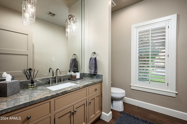 bathroom featuring wood-type flooring, vanity, and toilet