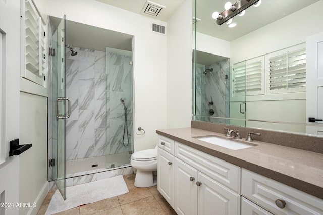 bathroom featuring tile patterned flooring, vanity, toilet, and an enclosed shower