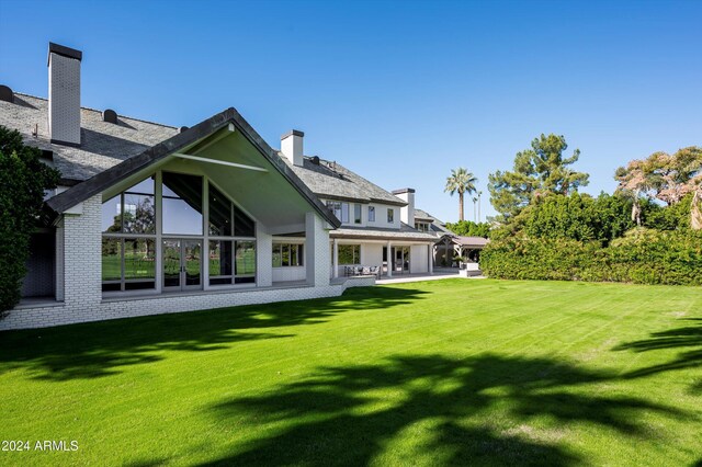 back of house featuring a lawn