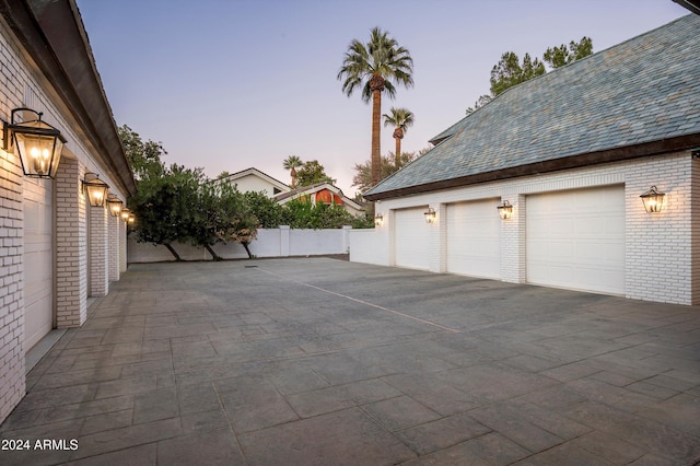 view of garage at dusk