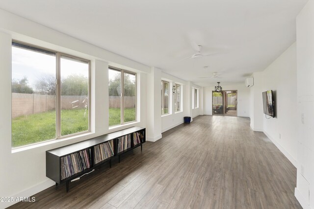 unfurnished sunroom with radiator, ceiling fan, and a wall unit AC