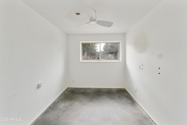 spare room featuring a ceiling fan, baseboards, and concrete floors