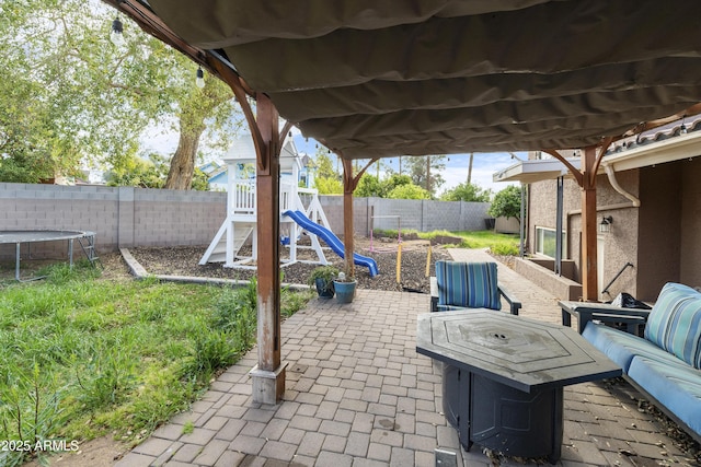 view of patio / terrace featuring a playground, a trampoline, and a fenced backyard