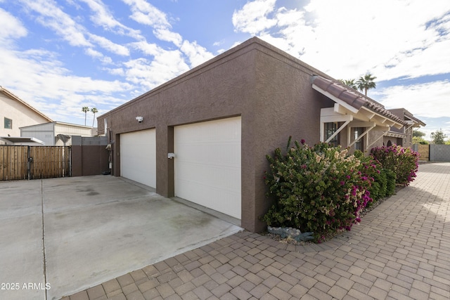 garage featuring fence and a gate