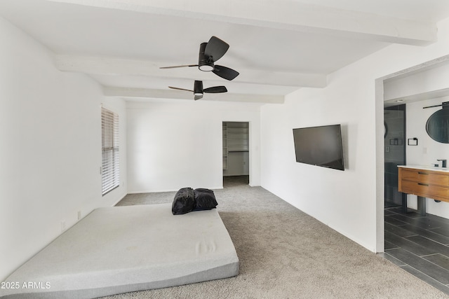 carpeted bedroom with beam ceiling, ensuite bath, and ceiling fan