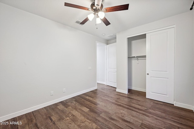 unfurnished bedroom with ceiling fan, dark hardwood / wood-style floors, and a closet