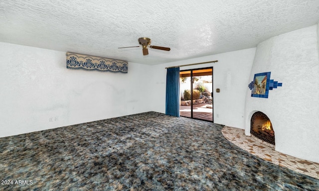 unfurnished living room with carpet flooring, a textured ceiling, and ceiling fan