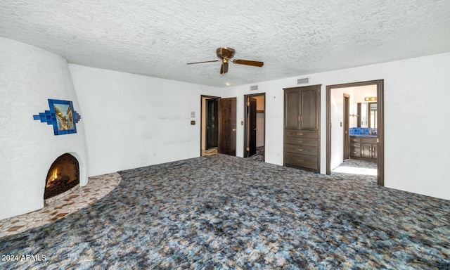 unfurnished bedroom featuring carpet, ceiling fan, a textured ceiling, and ensuite bath