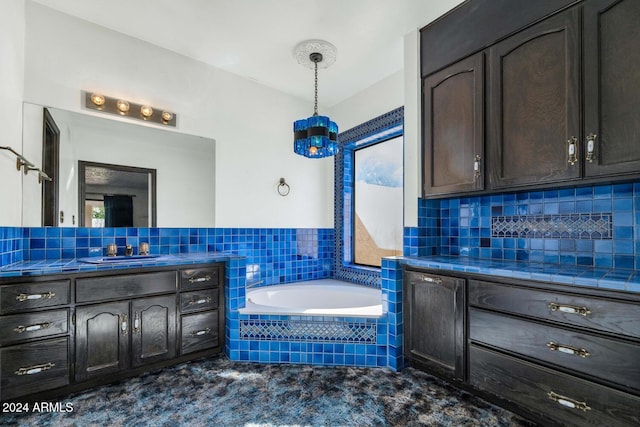 bathroom with backsplash, tiled tub, and vanity