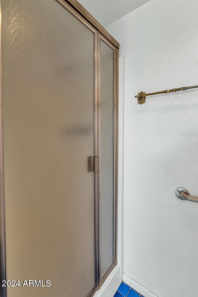 bathroom with tile patterned flooring and an enclosed shower