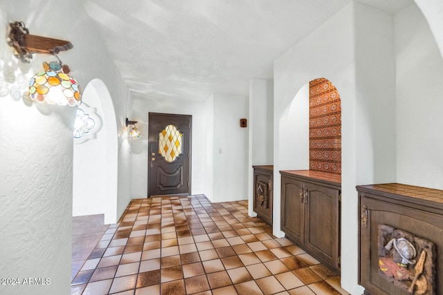 tiled foyer with a textured ceiling