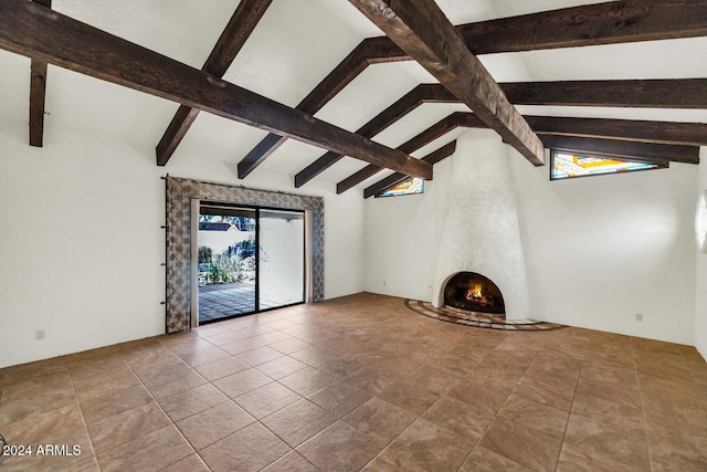 unfurnished living room with tile patterned floors, vaulted ceiling with beams, and a fireplace