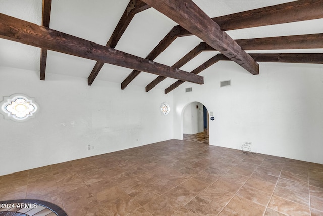 unfurnished living room with vaulted ceiling with beams