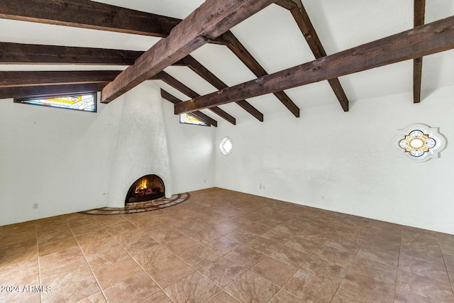 unfurnished living room featuring vaulted ceiling with beams