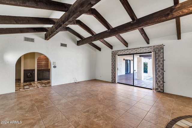 unfurnished living room featuring vaulted ceiling with beams and light tile patterned flooring