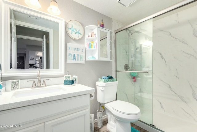 bathroom featuring vanity, toilet, and a shower with door