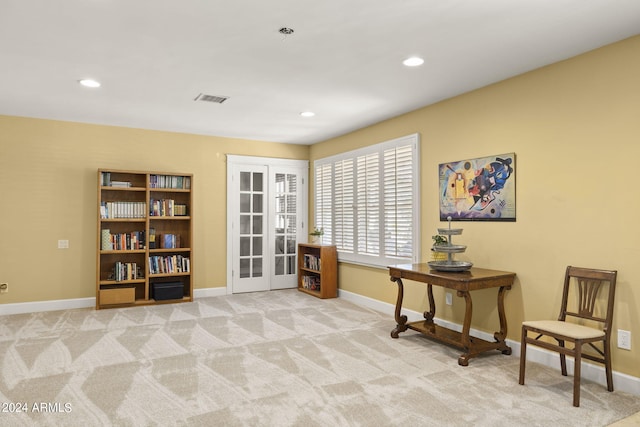 sitting room featuring light carpet and french doors