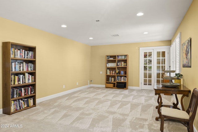 sitting room with french doors and light colored carpet