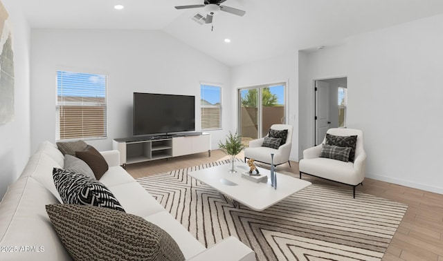 living room with lofted ceiling, ceiling fan, light hardwood / wood-style flooring, and a healthy amount of sunlight