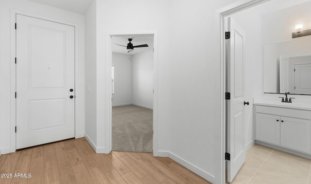 hall featuring sink and light wood-type flooring