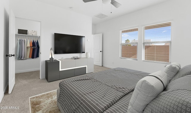 bedroom with ceiling fan, light colored carpet, and a closet