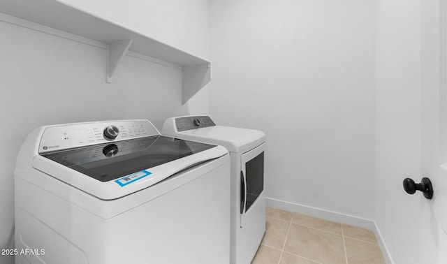 washroom with washing machine and dryer and light tile patterned flooring