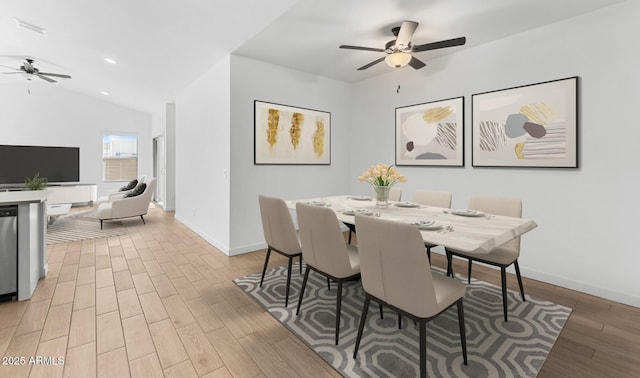 dining area featuring lofted ceiling, wood-type flooring, and ceiling fan