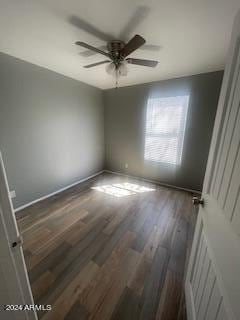 empty room with ceiling fan and dark hardwood / wood-style flooring