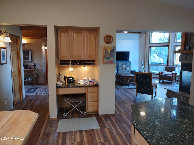 kitchen featuring dark hardwood / wood-style floors and dark stone countertops