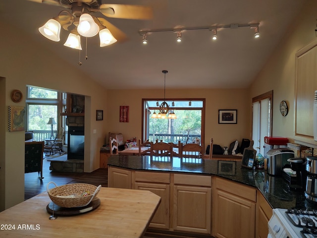 kitchen featuring pendant lighting, lofted ceiling, ceiling fan with notable chandelier, and dark hardwood / wood-style flooring