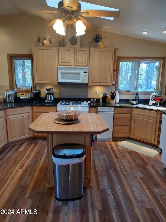 kitchen with white appliances, butcher block countertops, lofted ceiling, and plenty of natural light