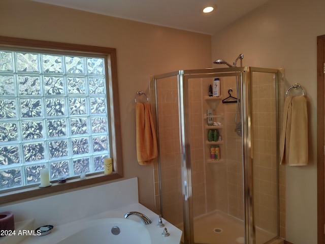 bathroom featuring independent shower and bath