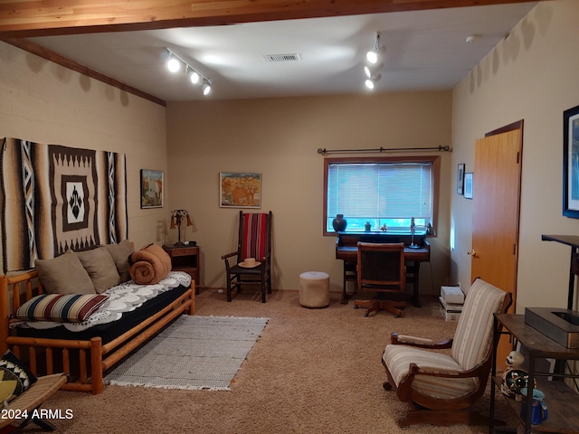 carpeted living room featuring beam ceiling and track lighting