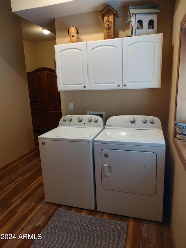 washroom featuring dark hardwood / wood-style floors, separate washer and dryer, and cabinets