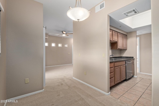 3434 E Baseline Rd Unit 126, Phoenix, AZ 85042 - kitchen with stainless steel dishwasher, ceiling fan, dark countertops, light carpet, and hanging light fixtures