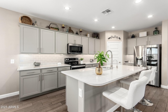 1297 W Chillingham Rd W, San Tan Valley, AZ 85143 - kitchen featuring appliances with stainless steel finishes, a sink, wood finished floors, baseboards, and recessed lighting